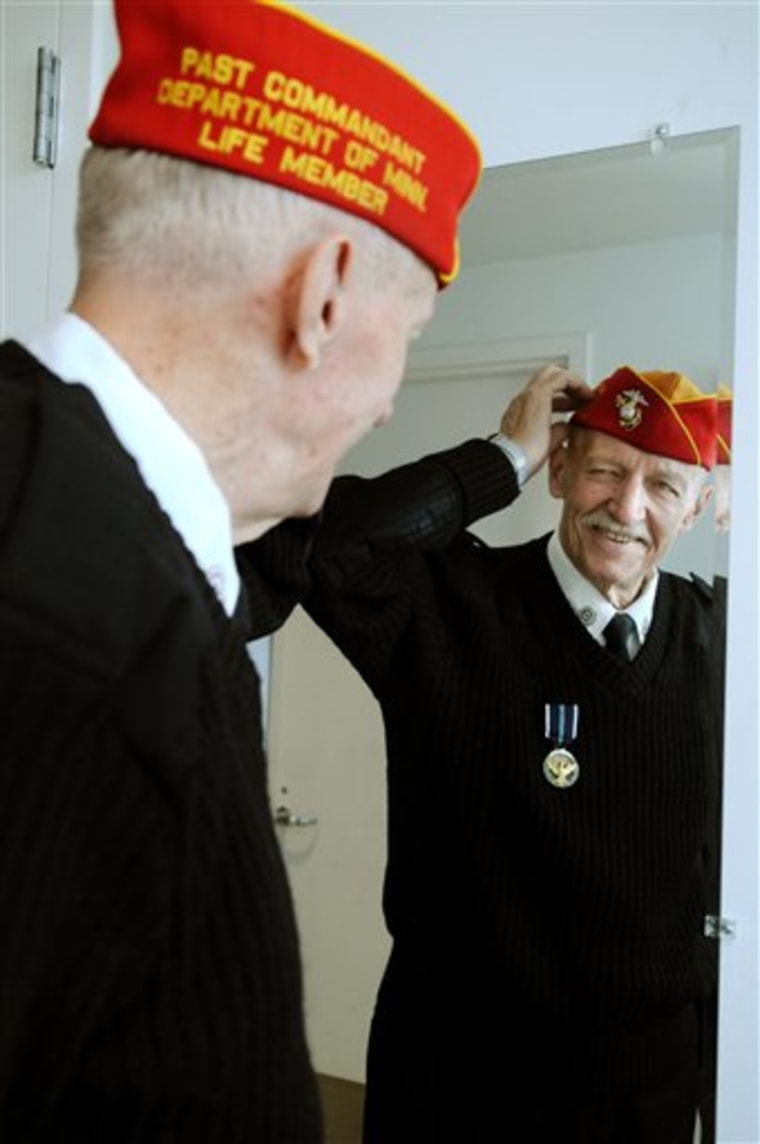 ** ADVANCE FOR USE ON THURSDAY, NOV. 11, 2010 AND THEREAFTER ** In this Friday Nov. 5, 2010 picture, veteran George Weiss Jr. straightens his cap before he heads out to command the Fort Snelling Memorial Rifle Squad for the day's funeral ceremonies at Fort Snelling National Cemetery in Bloomington, MInn. Weiss is the only survivor of the founding members of the squad, which is now made up of 128 members. Since 1979, it has performed at more than 57,000 vets' funerals. (AP Photo/Dawn Villella)